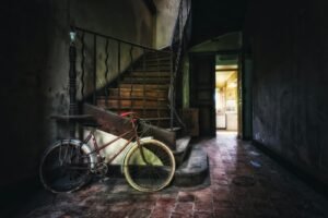 blue commuter bike parked beside brown wooden stairs