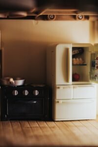 white top mount refrigerator beside black wooden cabinet